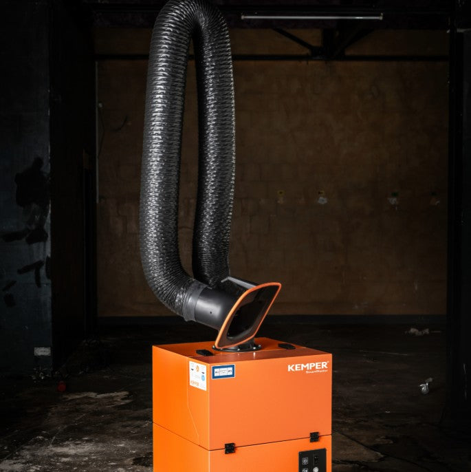 Orange KEMPER Smartmaster with an arm attached in a dark setting